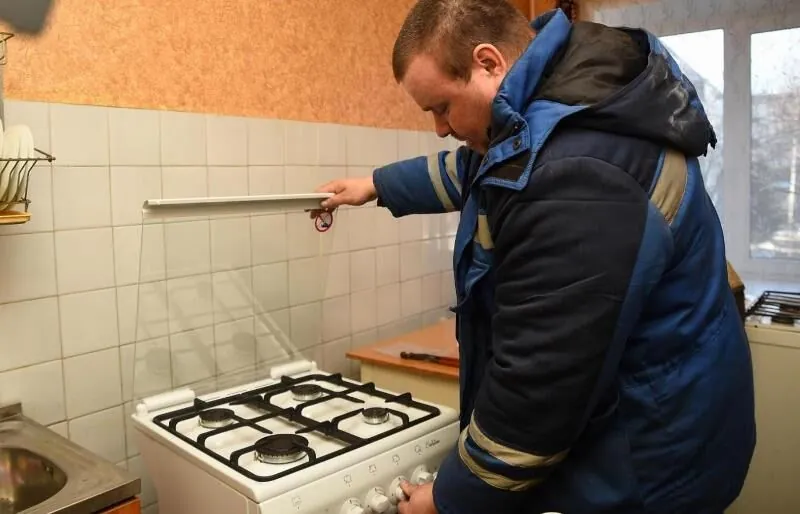 Майстер перевіряє газову плиту на кухні
